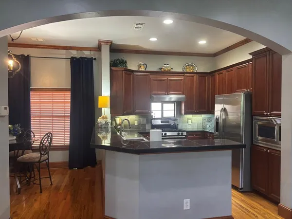 a kitchen with stainless steel appliances granite countertop a refrigerator and a stove