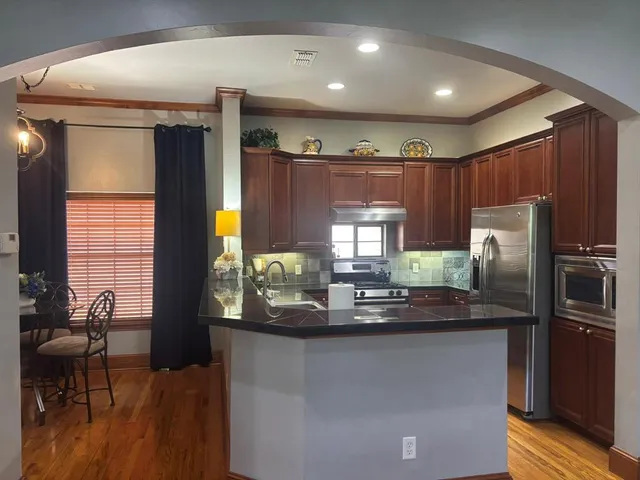 a kitchen with stainless steel appliances granite countertop a refrigerator and a stove