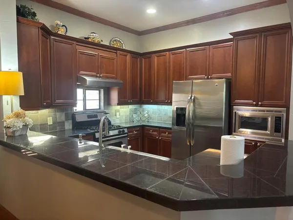 a kitchen with granite countertop a refrigerator and a sink