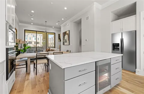 a kitchen with a table chairs refrigerator and cabinets