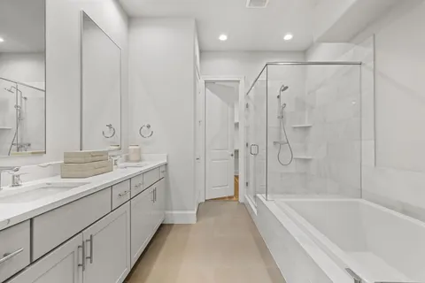 a spacious bathroom with a bathtub shower sink double and mirror