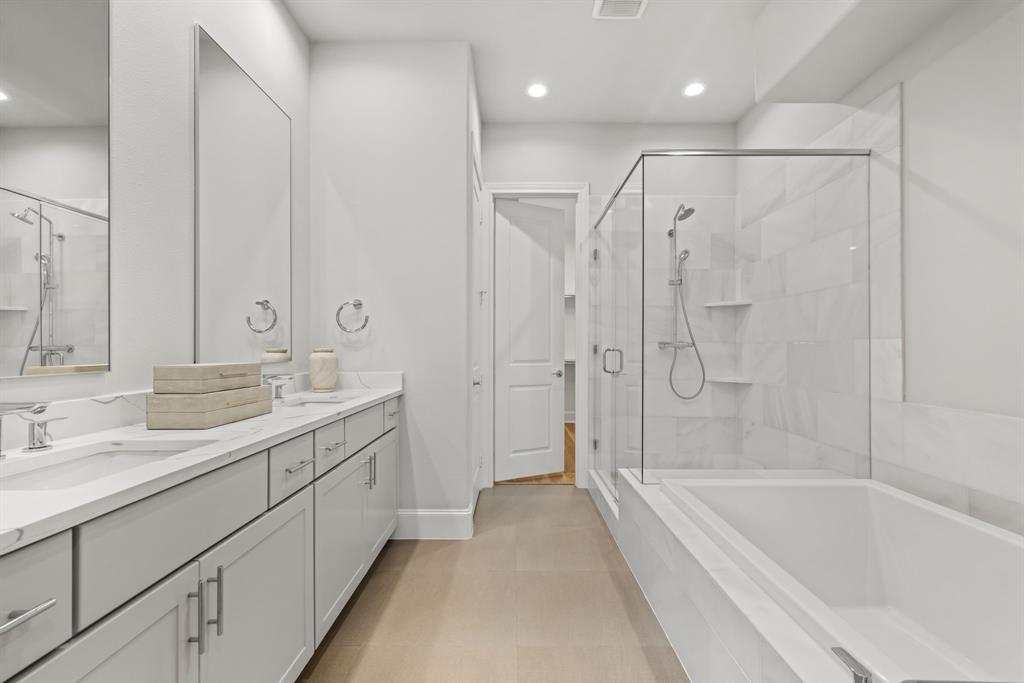 5446 Patterson Court Irving, TX 75039 - Photo 22 of 40 a spacious bathroom with a bathtub shower sink double and mirror