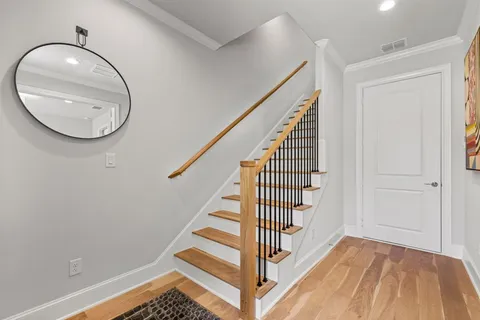 a view of a livingroom with wooden floor and staircase