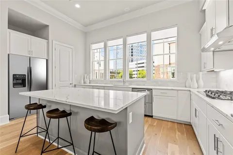 a kitchen with stainless steel appliances granite countertop a stove a sink and a refrigerator