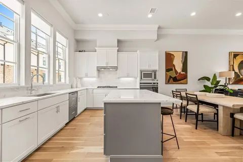 a kitchen with cabinets a sink a counter top space and living room view