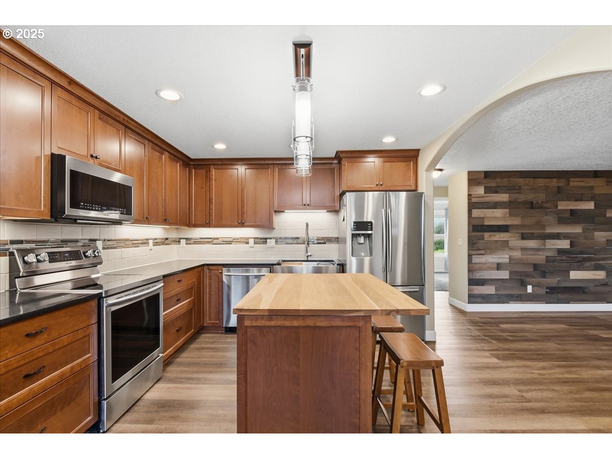 2519 Northwest 13th Street Battle Ground, WA 98604 - Photo 12 of 43 a kitchen with stainless steel appliances kitchen island granite countertop a sink stove and refrigerator