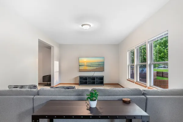 a living room with furniture flat screen tv and a large window
