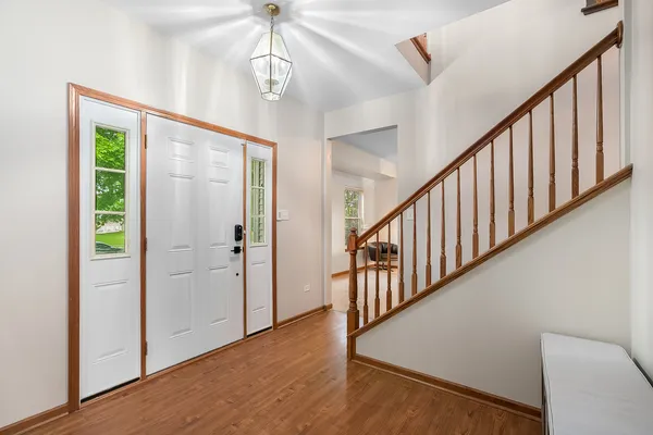 a view of a hallway with wooden floor and staircase