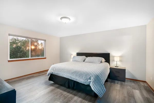 a bedroom with a bed and wooden floor