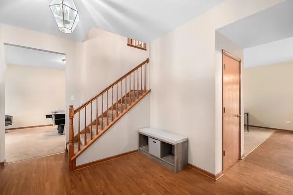 a view of a hallway with wooden floor and staircase