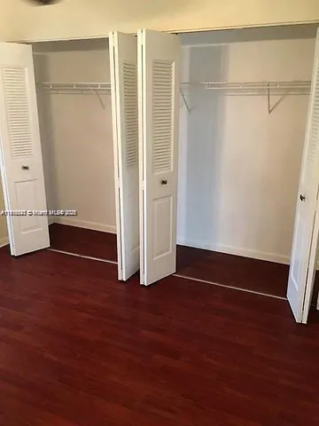 an empty room with wooden floor and closet
