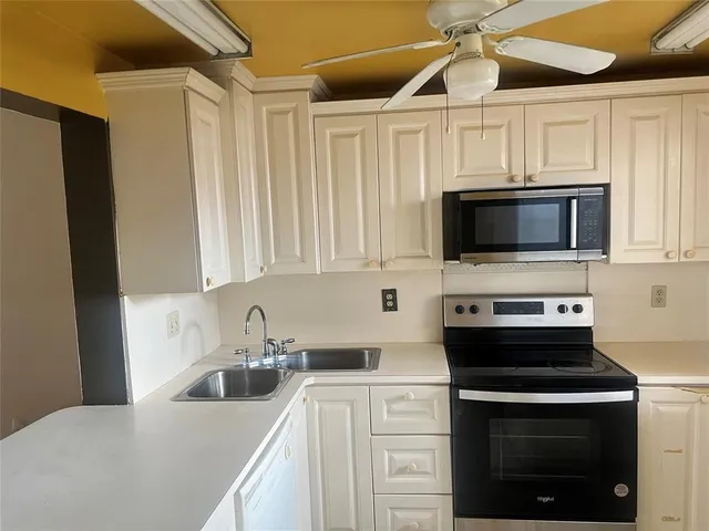 a kitchen with stainless steel appliances a stove a sink a microwave and cabinets
