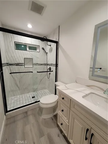 a bathroom with a granite countertop sink toilet and shower