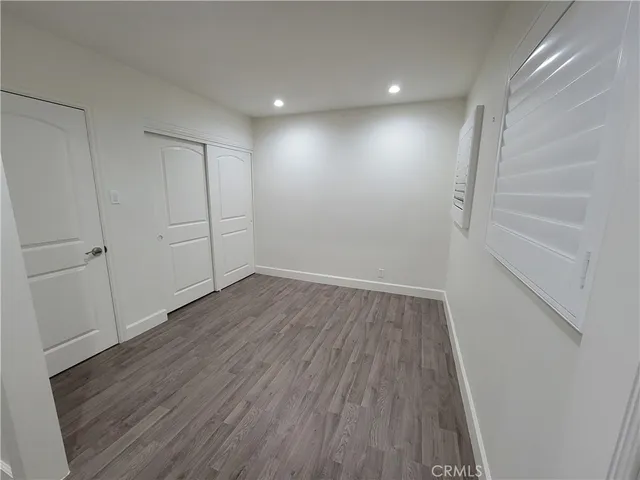 a view of an empty room with wooden floor and entryway