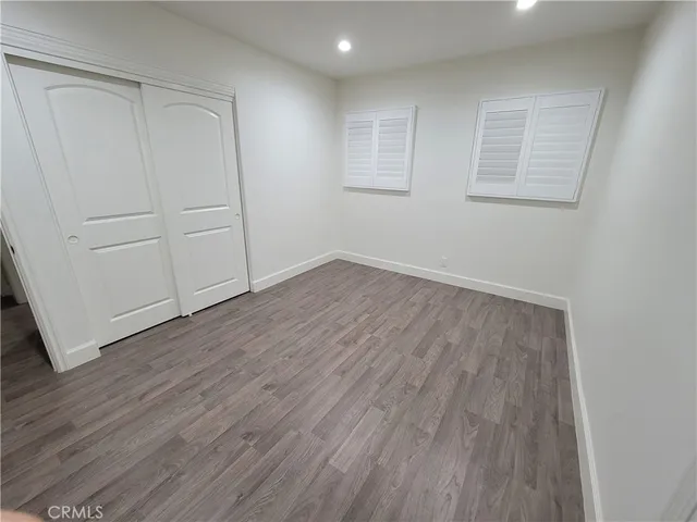 an empty room with wooden floor and white walls