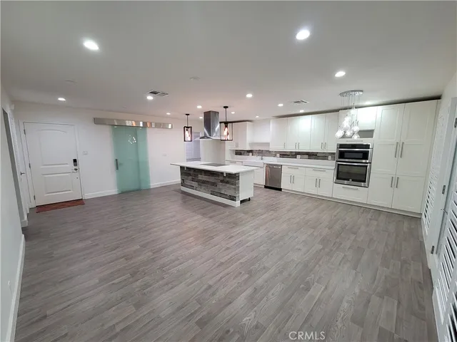 a large kitchen with stainless steel appliances kitchen island granite countertop a stove a sink and a refrigerator