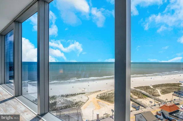 a view of ocean with boats and trees in the background