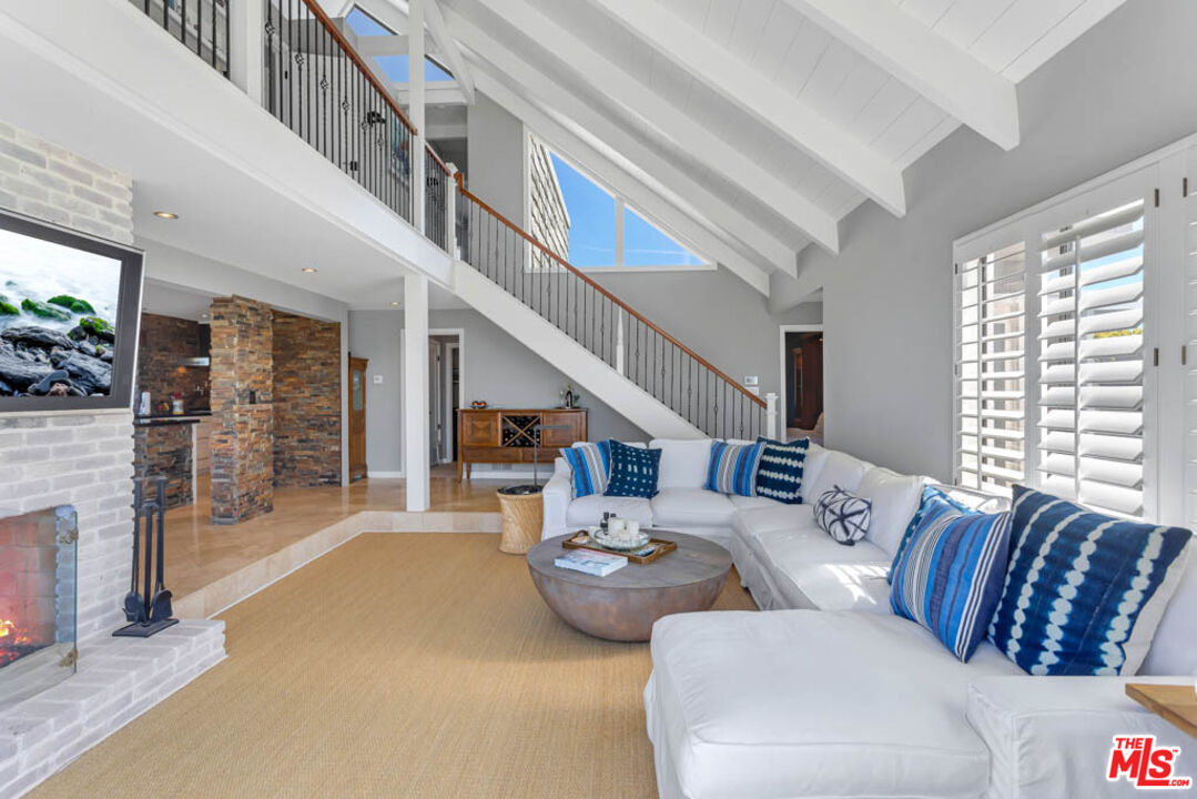 6439 Surfside Way Malibu, CA 90265 - Photo 11 of 32 a living room with furniture large window and a fireplace