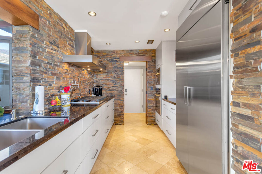 6439 Surfside Way Malibu, CA 90265 - Photo 16 of 32 a large white kitchen with a large counter top and stainless steel appliances
