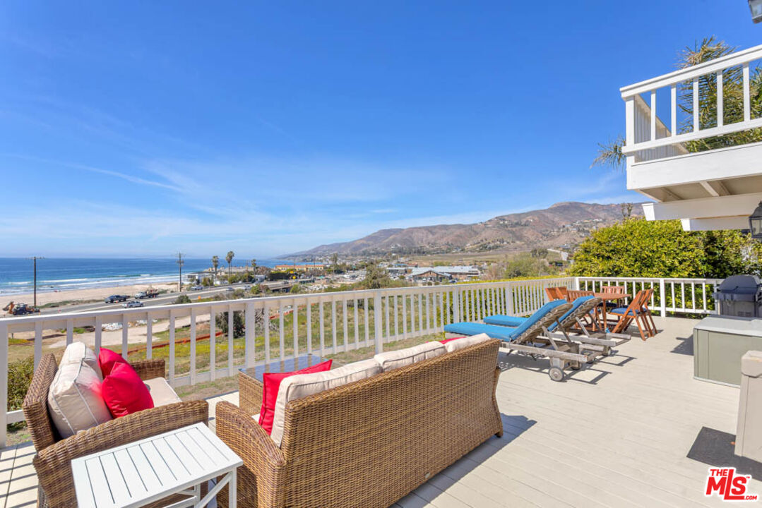 6439 Surfside Way Malibu, CA 90265 - Photo 28 of 32 a view of a balcony with two couches and a potted plant on a table