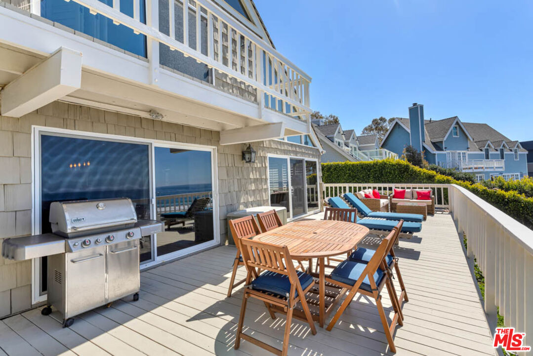 6439 Surfside Way Malibu, CA 90265 - Photo 29 of 32 a view of a roof deck with table and chairs couches with wooden floor