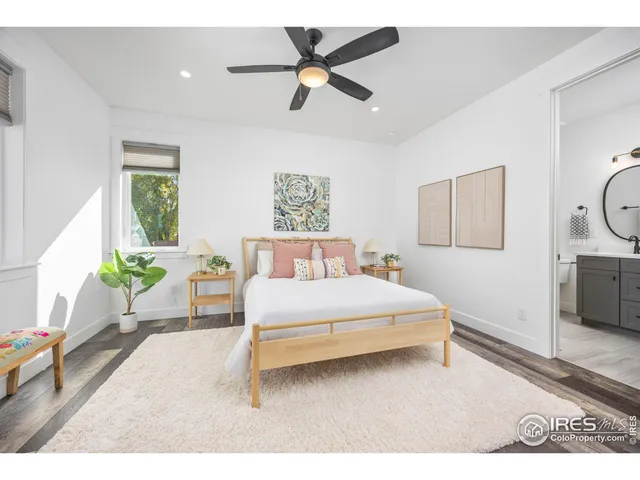 a bedroom with a bed chandelier and a window