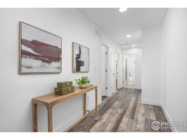 a hallway with painting on wall and wooden floor