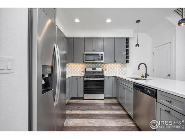 a kitchen with kitchen island a counter top space a sink and appliances