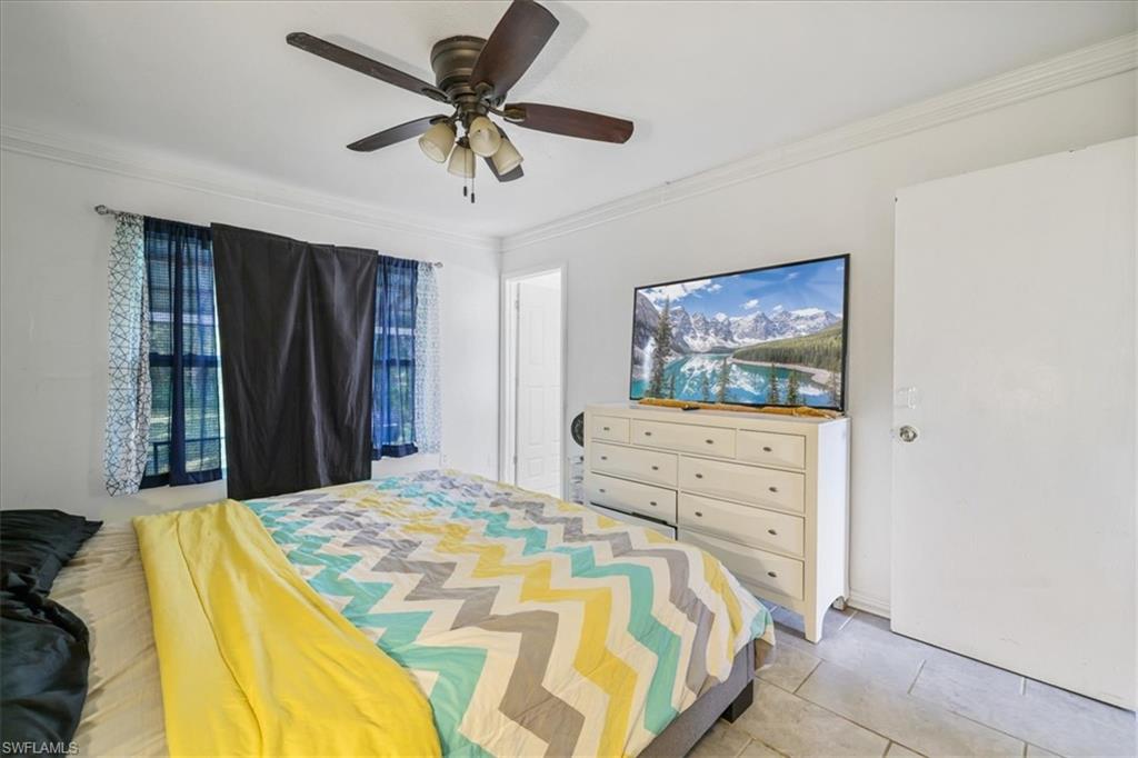 4077 South Edgewater Circle LaBelle, FL 33935 - Photo 14 of 30 a bedroom with a bed and a chandelier