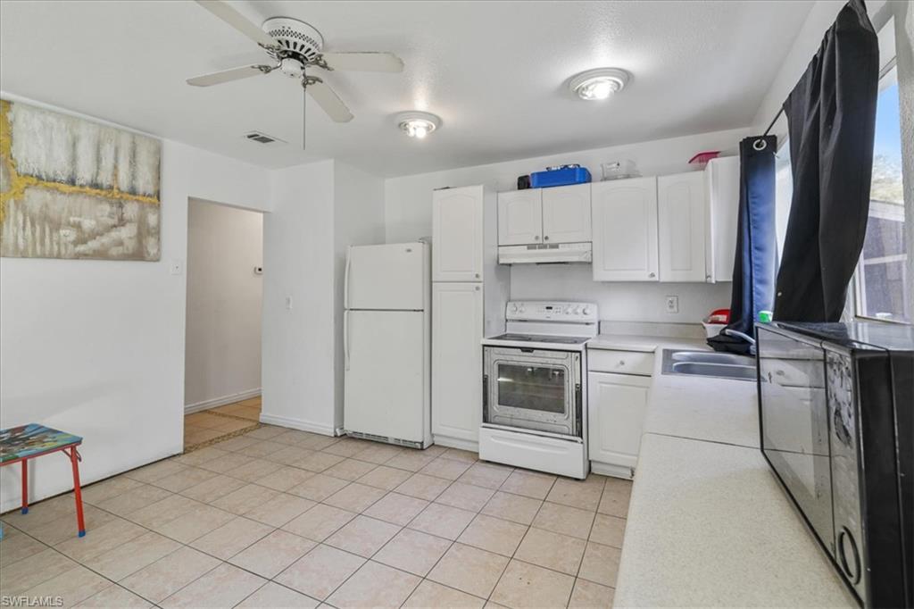 4077 South Edgewater Circle LaBelle, FL 33935 - Photo 10 of 30 a kitchen with white cabinets and appliances
