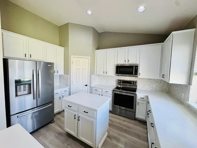a kitchen with stainless steel appliances and refrigerator