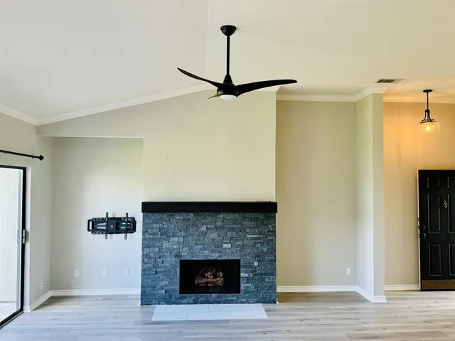 a room with a fireplace and a ceiling fan