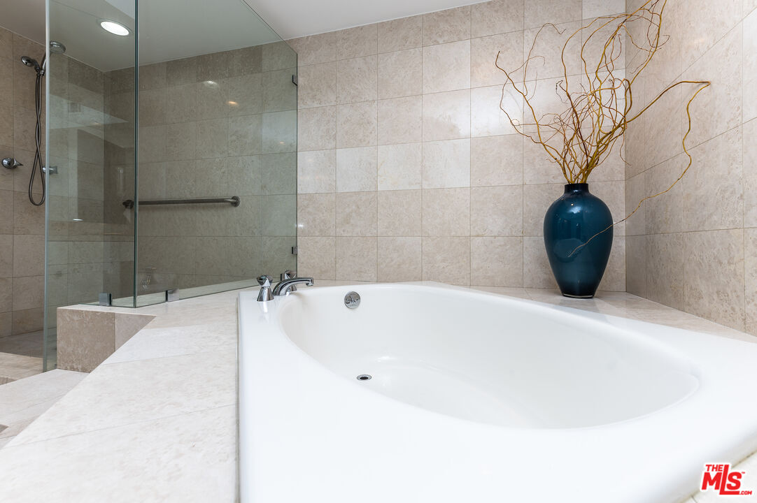 235 South Reeves Drive, Unit 301 Beverly Hills, CA 90212 - Photo 11 of 18 a bathroom with a bathtub and a shower
