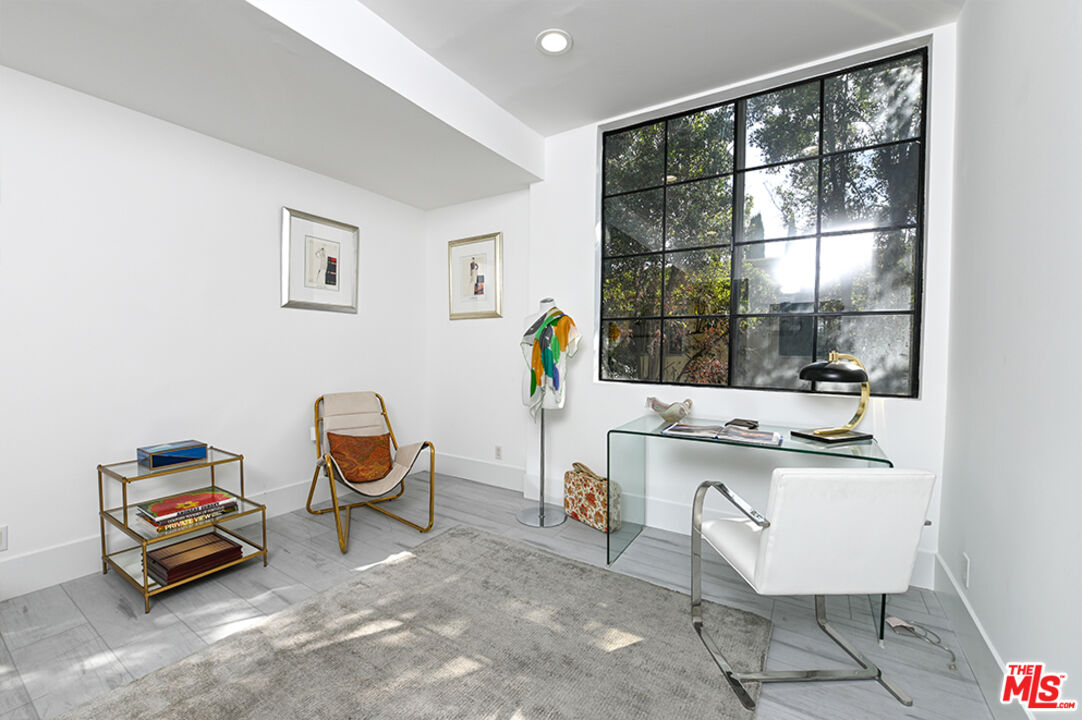 235 South Reeves Drive, Unit 301 Beverly Hills, CA 90212 - Photo 13 of 18 a living room with furniture a window and gym equipment