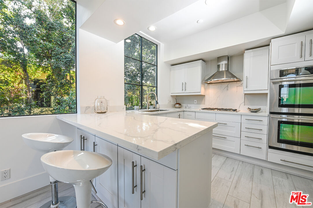 235 South Reeves Drive, Unit 301 Beverly Hills, CA 90212 - Photo 6 of 18 a kitchen with a sink cabinets and window
