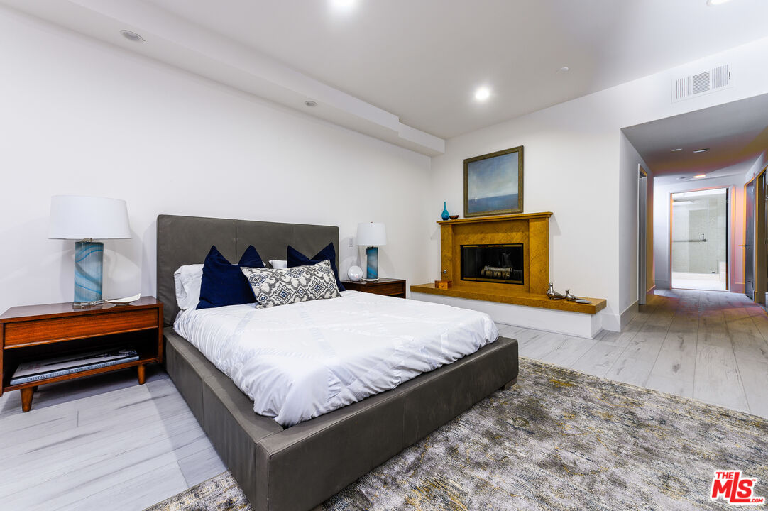 235 South Reeves Drive, Unit 301 Beverly Hills, CA 90212 - Photo 8 of 18 a spacious bedroom with a bed and a fireplace