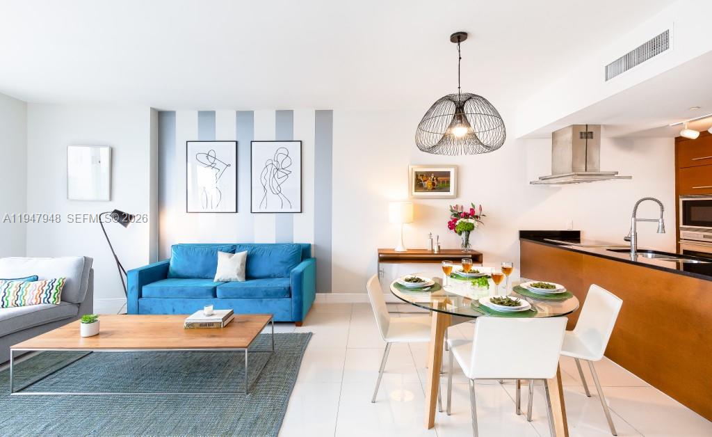 a living room with furniture a kitchen island and chairs in it