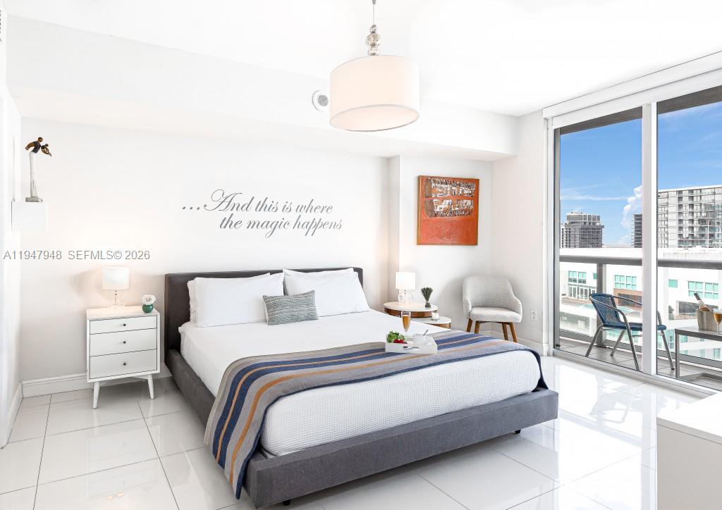 485 Brickell Avenue, Unit 4307 Miami, FL 33131 - Photo 8 of 21 a bedroom with a bed a table and chair