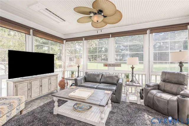 a living room with furniture a flat screen tv and a large window