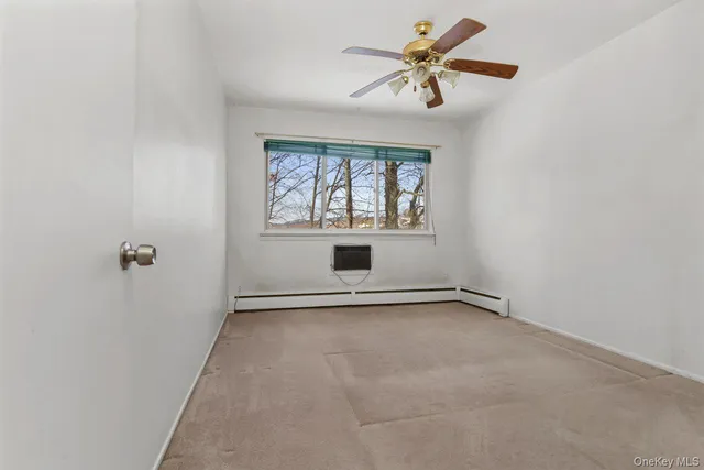 an empty room with a window and a fan