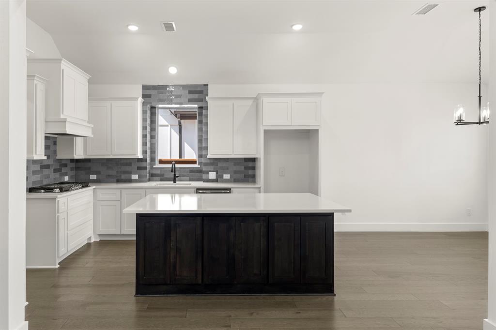 1335 Eclipse Way Wylie, TX 75098 - Photo 11 of 34 a kitchen with kitchen island sink and cabinets