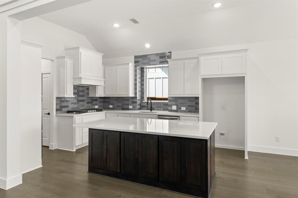 1335 Eclipse Way Wylie, TX 75098 - Photo 14 of 34 a kitchen with kitchen island granite countertop a sink cabinets and stainless steel appliances