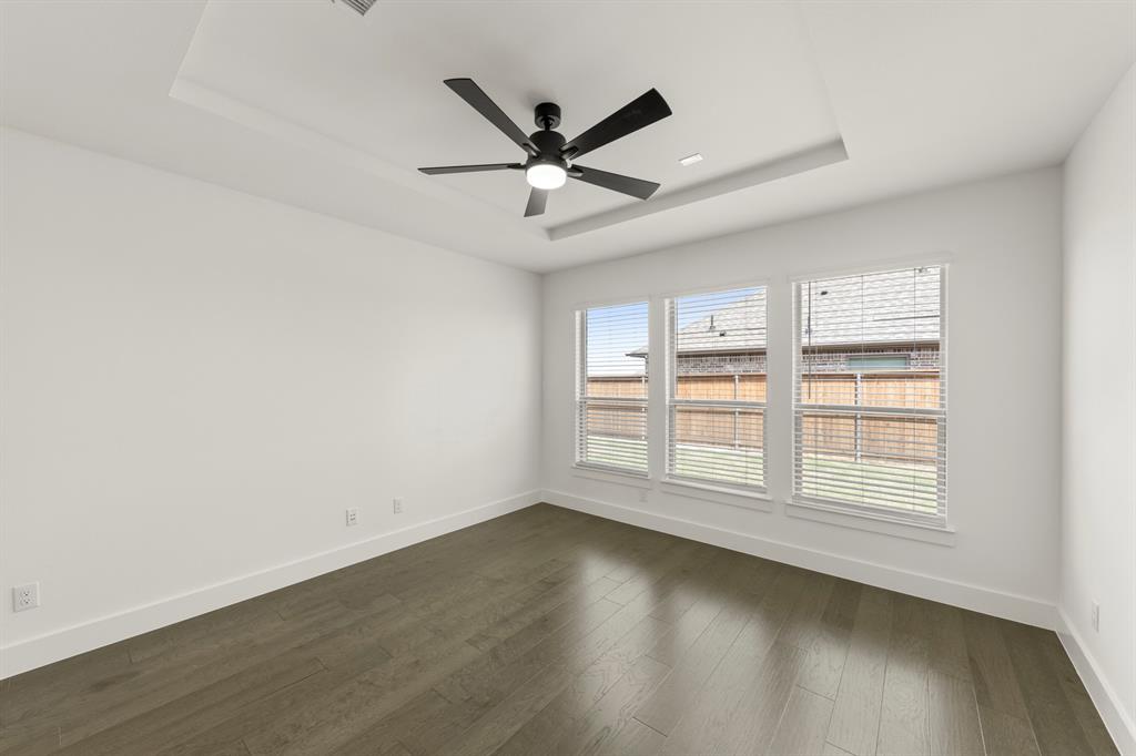 1335 Eclipse Way Wylie, TX 75098 - Photo 19 of 34 an empty room with wooden floor fan and windows