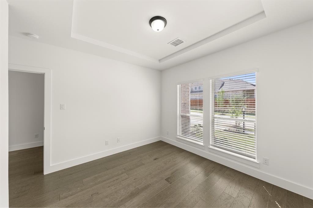 1335 Eclipse Way Wylie, TX 75098 - Photo 4 of 34 an empty room with wooden floor and windows