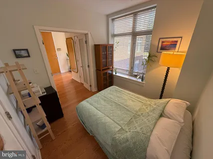 a bedroom with a bed and wooden floor