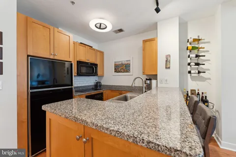 a kitchen with stainless steel appliances granite countertop a sink stove and microwave