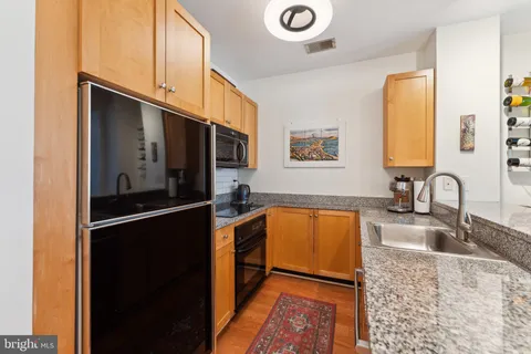 a kitchen with stainless steel appliances granite countertop a refrigerator and a sink