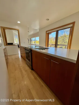 a open kitchen with wooden floor and stainless steel appliances