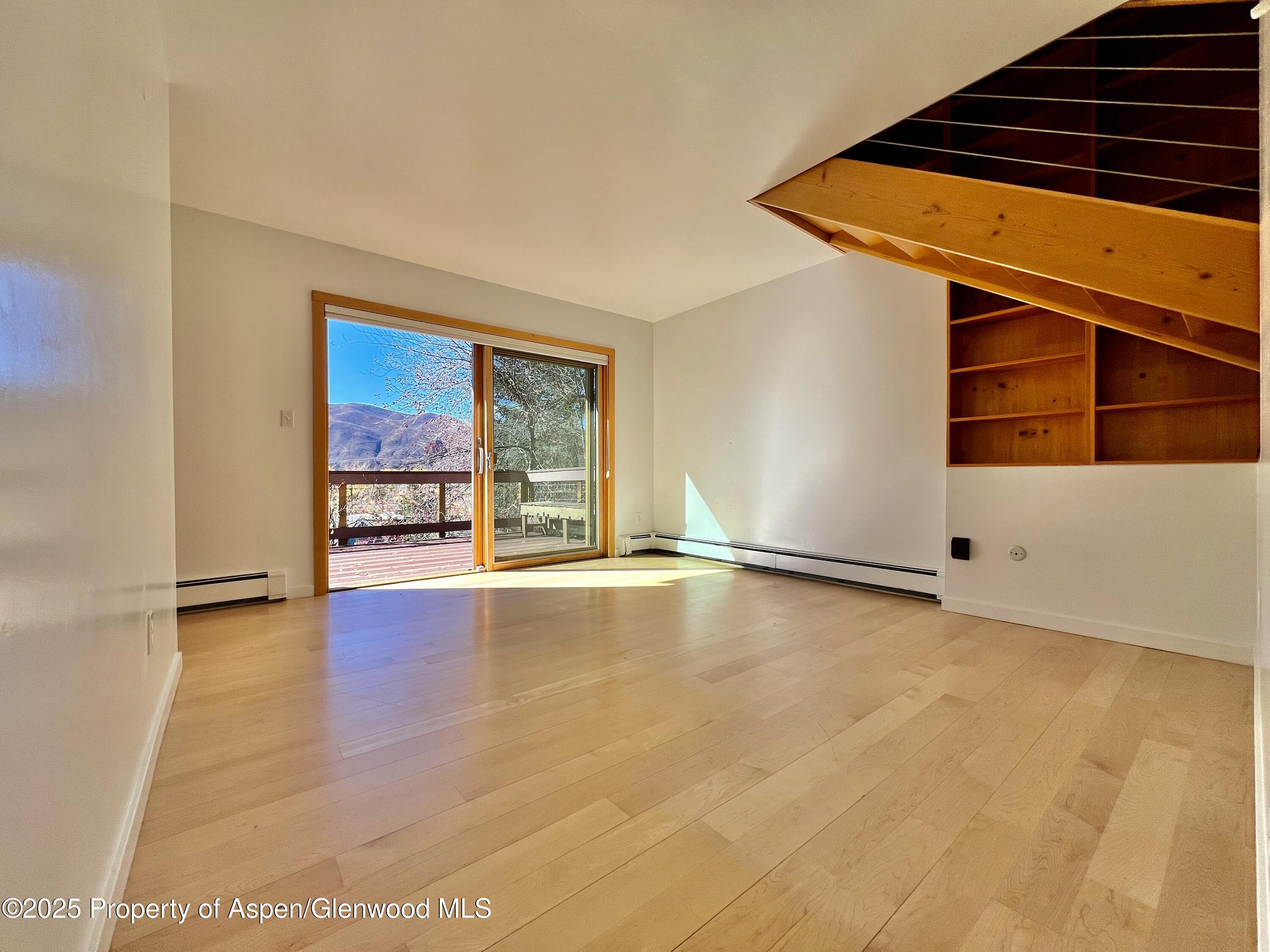 216 East Homestead Drive Basalt, CO 81621 - Photo 6 of 26 an empty room with wooden floor and windows