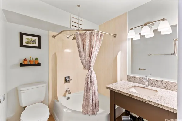 a bathroom with a granite countertop sink a toilet and a mirror